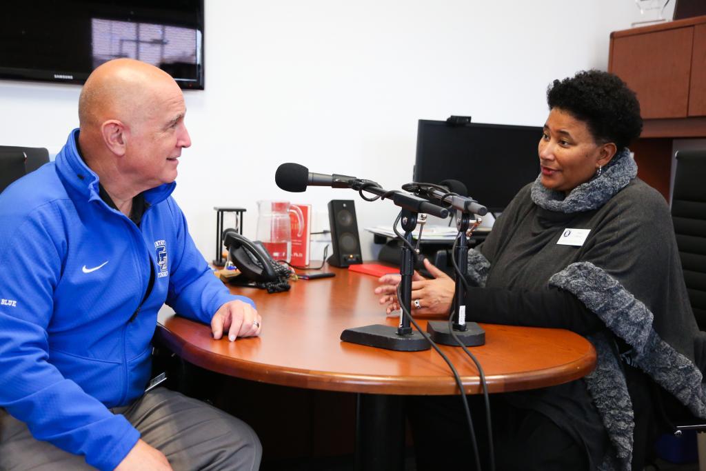 Woman interviewing a man during a podcast.
